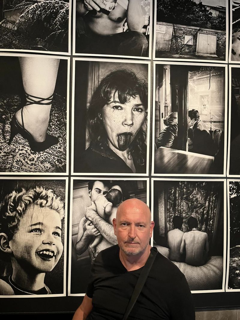 Portrait in front of a black and white photo wall